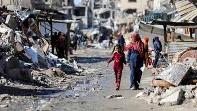 Palestinians walk past the ruins of houses destroyed during Israel's military offensive, amid the ongoing conflict between Israel and Hamas, in Gaza City. (Reuters)