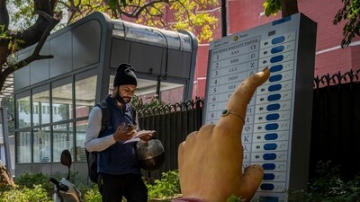 A man walks past a large model of a woman's finger pressing a button of an electronic voting machine displayed outside the office of Election Commission of India in New Delhi, India, Wednesday, March 20, 2024. From April 19 to June 1, nearly 970 million Indians - or over 10% of the world's population - will vote in the country's general elections. The mammoth electoral exercise is the biggest anywhere in the world - and will take 44 days to complete before results are announced on June 4. (AP Photo/Altaf Qadri) (AP) A man walks past a large model of a woman's finger pressing a button of an electronic voting machine displayed outside the office of Election Commission of India in New Delhi, India, Wednesday, March 20, 2024. From April 19 to June 1, nearly 970 million Indians - or over 10% of the world's population - will vote in the country's general elections. The mammoth electoral exercise is the biggest anywhere in the world - and will take 44 days to complete before results are announced on June 4. (AP Photo/Altaf Qadri) (AP)