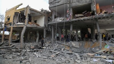 Palestinians search the rubble of a family home following Israeli bombardment west of the Nuseirat refugee camp in the central Gaza Strip. (AFP)