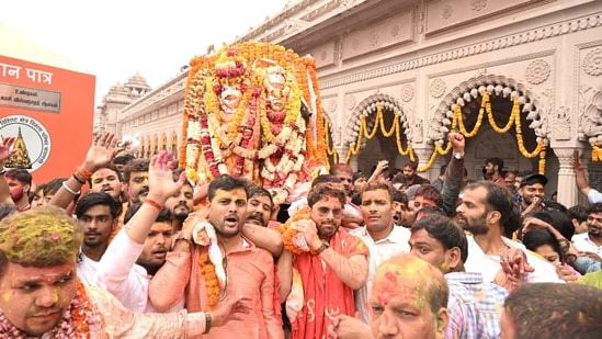 Devotees holding flags take part in religious procession Khatu Shyam Ji Yatra on the occasion of Rangbhari Ekadashi, at Shri Kashi Vishwanath Temple, in Varanasi on March 20.(ANI)