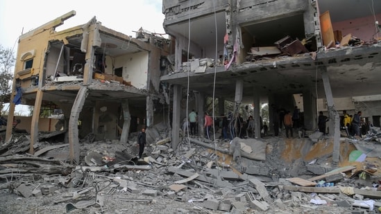 Palestinians search the rubble of a family home following Israeli bombardment west of the Nuseirat refugee camp in the central Gaza Strip. (AFP)