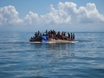 Rohingya refugees are seen on a capsized boat before being rescued in the waters of West Aceh, Indonesia.