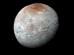 Pluto's moon Charon is pictured in the centre of the image. Pluto's moon Charon is pictured in the centre of the image.