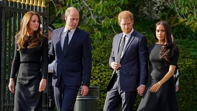 Britain's Prince William, second left, Kate, Princess of Wales, left, Britain's Prince Harry, second right, and Meghan, Duchess of Sussex view the floral tributes for the late Queen Elizabeth II outside Windsor Castle, in Windsor, England on Sept. 10, 2022. (AP Photo/Martin Meissner, File) (AP)