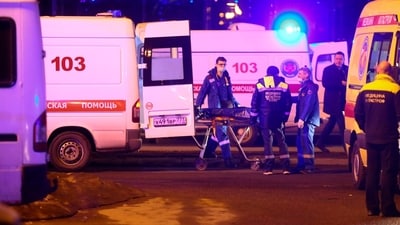 Medics transport a body of a victim a waiting ambulance near the burning building of the Crocus City Hall on the western edge of Moscow, Russia. (AP) Medics transport a body of a victim a waiting ambulance near the burning building of the Crocus City Hall on the western edge of Moscow, Russia. (AP)