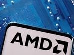 A smartphone with a displayed AMD logo is placed on a computer motherboard in this illustration.