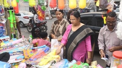 rephrase this: People thronged markets across the country, ahead of Holi, making last-minute purchases of colours or gulals, trendy water guns, and colourful wigs.&nbsp; (HT Photo/Santosh Kumar)