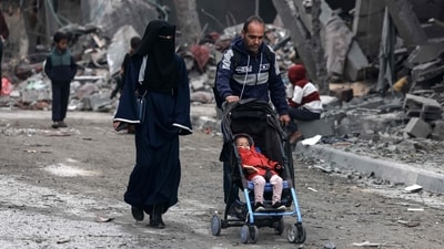Members of a Palestinian family walk near a building destroyed by overnight Israeli bombardment in Rafah in the southern Gaza Strip on March 24, 2024, amid the ongoing conflict between Israel and the militant group Hamas. (AFP) Members of a Palestinian family walk near a building destroyed by overnight Israeli bombardment in Rafah in the southern Gaza Strip on March 24, 2024, amid the ongoing conflict between Israel and the militant group Hamas. (AFP)