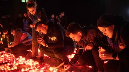 People light candles during a memorial gathering in Donetsk, Russian-controlled Ukraine, on March 24, 2024, as Russia observes a national day of mourning after a concert hall massacre that killed more than 130 people. (AFP)