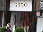 People walk past the Gucci store on Fifth Avenue in New York City. French luxury group Kering, owner of Gucci, had its shares drop 14% after the announced that Gucci sales are set to fall 20% year-on-year in Q1, amid declining Asia transactions.