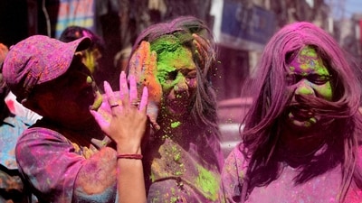 A man smears the face of a woman with colored powder as they celebrate Holi, the Hindu festival of colors, in Jammu. (AP)