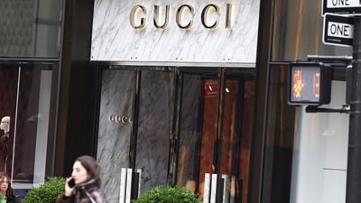 People walk past the Gucci store on Fifth Avenue in New York City. French luxury group Kering, owner of Gucci, had its shares drop 14% after the announced that Gucci sales are set to fall 20% year-on-year in Q1, amid declining Asia transactions. (AFP)