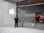 A man stands outside a recently-opened Apple Store in Shanghai's Jing'an district on March 26, 2024. (Photo by Hector RETAMAL / AFP)