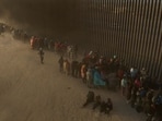 A drone view shows migrants enduring cold and blustery weather as they line up against the border wall to surrender to immigration officials after breaching a razor wire-laden fence along the bank of the Rio Grande River in El Paso, Texas, U.S., March 25, 2024. REUTERS/Adrees Latif