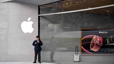 A man stands outside a recently-opened Apple Store in Shanghai's Jing'an district on March 26, 2024. (Photo by Hector RETAMAL / AFP) (AFP)