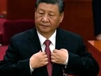 Chinese President Xi Jinping adjusts his jacket during the closing session of the National People's Congress held at the Great Hall of the People in Beijing. Chinese President Xi Jinping adjusts his jacket during the closing session of the National People's Congress held at the Great Hall of the People in Beijing.