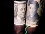 Japanese yen and US dollar banknotes are seen with a currency exchange rate graph in this illustration.