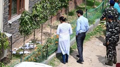 ED officials picking up torn documents outside Punjab excise and taxation commissioner Varun Roojam's residence in Sector 20 Chandigarh on Wednesday. (Ravi Kumar/HT) ED officials picking up torn documents outside Punjab excise and taxation commissioner Varun Roojam's residence in Sector 20 Chandigarh on Wednesday. (Ravi Kumar/HT)