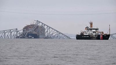 The US Coast Guard Cutter Frank Drew (R) patrols near the collapsed Francis Scott Key Bridge after it was struck by the container ship Dali in Baltimore, Maryland, on March 27, 2024. (AFP)