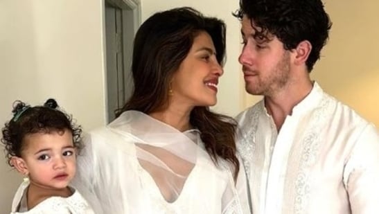 Pictures and videos of Priyanka and Nick celebrating Holi went viral on social media. In the first picture, Priyanka can be seen wearing a white anarkali suit with black bindi and held Malti in her arms. Nick wore a white kurta set and can be seen standing behind them as they pose for a family picture.(Instagram)