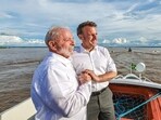 Handout picture released by the Brazilian Presidency showing Brazilian President Luiz Inacio Lula da Silva (L) and French President Emmanuel Macron holding hands as they hold a bilateral meeting. 