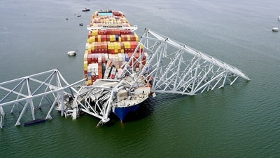 In this aerial image released by the Maryland National Guard, the cargo ship Dali is stuck under part of the structure of the Francis Scott Key Bridge after the ship hit the bridge (AP) In this aerial image released by the Maryland National Guard, the cargo ship Dali is stuck under part of the structure of the Francis Scott Key Bridge after the ship hit the bridge (AP)