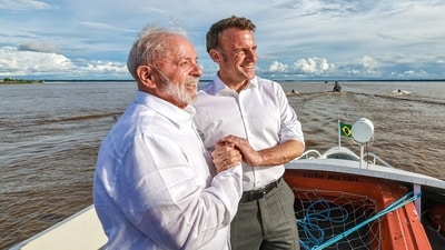 Handout picture released by the Brazilian Presidency showing Brazilian President Luiz Inacio Lula da Silva (L) and French President Emmanuel Macron holding hands as they hold a bilateral meeting. (AFP)
