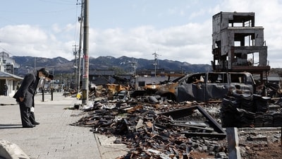 TOPSHOT - Japan's Emperor Naruhito (L) and Empress Masako (2nd L) bow as they pay their respects at the site where a large-scale fire broke out on New Year's Day following a 7.5 magnitude earthquake in the area, in the city of Wajima, Ishikawa prefecture on March 22, 2024. (Photo by JAPAN POOL / JIJI Press / AFP) / Japan OUT (AFP)
