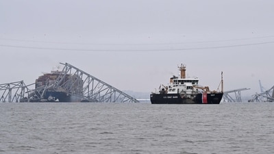 TOPSHOT - The US Coast Guard Cutter Frank Drew (R) patrols near the collapsed Francis Scott Key Bridge after it was struck by the container ship Dali in Baltimore, Maryland, on March 27, 2024. (AFP) TOPSHOT - The US Coast Guard Cutter Frank Drew (R) patrols near the collapsed Francis Scott Key Bridge after it was struck by the container ship Dali in Baltimore, Maryland, on March 27, 2024. (AFP)