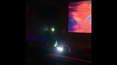 Peak Bengaluru: Man working on his laptop inside the theatre. (X/@rishfishtish) Peak Bengaluru: Man working on his laptop inside the theatre. (X/@rishfishtish)