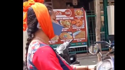 Snapshot of the woman with her phone wrapped to her ear. (X/@3rdEyeDude) Snapshot of the woman with her phone wrapped to her ear. (X/@3rdEyeDude)