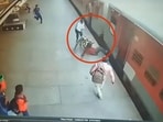 Railways staff present on the platform saving the passenger's life as other passengers run towards them to help. 