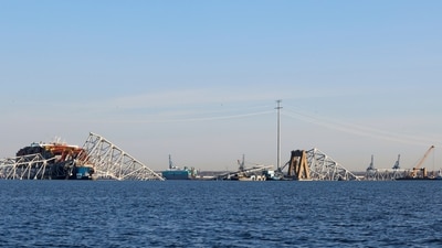 A Maryland Natural Resources Police helicopter flies overhead as wreckage of the Francis Scott Key Bridge rests on the container ship Dali (AP) A Maryland Natural Resources Police helicopter flies overhead as wreckage of the Francis Scott Key Bridge rests on the container ship Dali (AP)