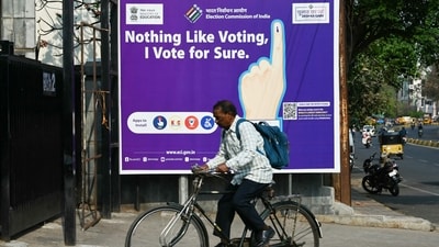 A man rides past an election awareness poster displayed along a street ahead of India�s upcoming general elections, in Hyderabad on March 26, 2024. (Photo by NOAH SEELAM / AFP) (AFP) A man rides past an election awareness poster displayed along a street ahead of India�s upcoming general elections, in Hyderabad on March 26, 2024. (Photo by NOAH SEELAM / AFP) (AFP)