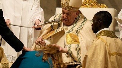 Pope Francis baptises a faithful as he presides over the Easter vigil celebration in St. Peter's Basilica at the Vatican on Saturday. (AP)
