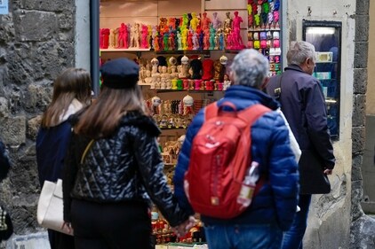People walk past a shop selling souvenirs of Michelangelo's 16th century statue of David, in downtown Florence, central Italy. (AP)