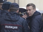 Russian opposition leader Alexei Navalny is escorted upon his arrival for a hearing in Moscow after being detained at a protest against corruption and demanding the resignation of Prime Minister Dmitry Medvedev.