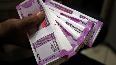A cashier displays the new 2000 Indian rupee banknotes inside a bank in Jammu. (REUTERS)