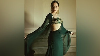 Tamannaah wore the saree with statement accessories, including gold Chandelier earrings and matching strappy pumps featuring killer high heels. A centre-parted pulled-back low twisted bun added a fierce aesthetic to Tamannaah's bombshell ethnic avatar. (Instagram) Tamannaah wore the saree with statement accessories, including gold Chandelier earrings and matching strappy pumps featuring killer high heels. A centre-parted pulled-back low twisted bun added a fierce aesthetic to Tamannaah's bombshell ethnic avatar. (Instagram)