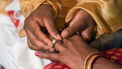 A groom puts a ring on his bride's finger. (AP) A groom puts a ring on his bride's finger. (AP)
