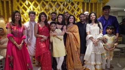 Priyanka Chopra opted for a red saree and matching blouse. Nick Jonas stood beside her in the pictures, clad in a white kurta-pyjama and beige jacket. Priyanka Chopra opted for a red saree and matching blouse. Nick Jonas stood beside her in the pictures, clad in a white kurta-pyjama and beige jacket.