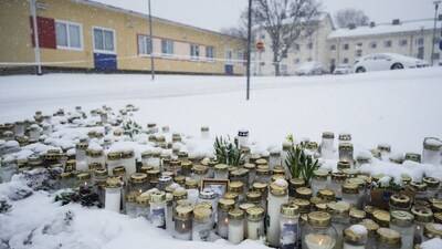 Candles and flowers are placed in front of the Viertola School to pay tribute to victims in Vantaa, in the north of the Finnish capital Helsinki. (AFP)
