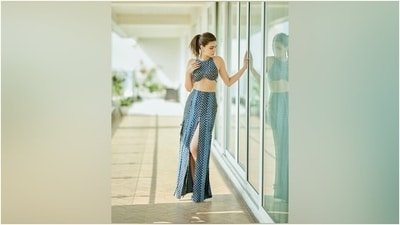 Kriti's sleeveless top has a round neckline, an asymmetric curved hem exposing Kriti's midriff, a racerback design, fitted bust cups, a check printed denim tie detail on the back, and a bodycon silhouette. (Instagram) Kriti's sleeveless top has a round neckline, an asymmetric curved hem exposing Kriti's midriff, a racerback design, fitted bust cups, a check printed denim tie detail on the back, and a bodycon silhouette. (Instagram)
