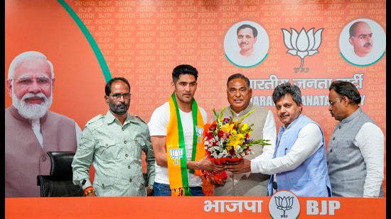 Boxer and former Congress leader Vijender Singh being greeted by BJP leader Ramvir Singh Bidhuri as he joins the party ahead of Lok Sabha elections, at BJP HQ in New Delhi on Wednesday. (PTI)