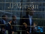 Workers are reflected in the windows of the Canary Wharf offices of JP Morgan in London.