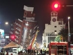 Emergency personnel stand in front of a partially collapsed building leaning over a street in Hualien, after a major earthquake hit Taiwan's east, on Wednesday. (AFP) Emergency personnel stand in front of a partially collapsed building leaning over a street in Hualien, after a major earthquake hit Taiwan's east, on Wednesday. (AFP)