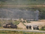 Israeli soldiers stand near military vehicles, amid the ongoing conflict between Israel and the Palestinian Islamist group Hamas. (Reuters)