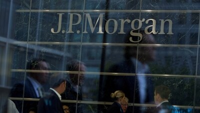 Workers are reflected in the windows of the Canary Wharf offices of JP Morgan in London. (Reuters)