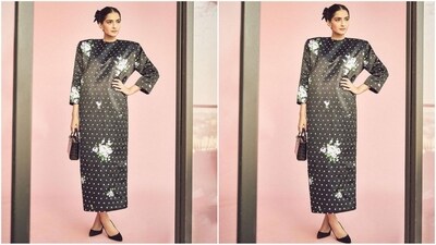 Her chic outfit comes in a stylish shade of black and features a chic white polka dot pattern all over. Power shoulders, elbow-length sleeves, a maxi hem, a straight fit and the enchanting floral print that adorns her dress all over gives her trendy look a touch of elegance.&nbsp; (Instagram/@sonamkapoor)