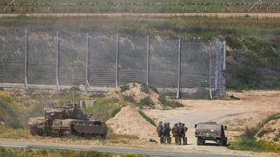 Israeli soldiers stand near military vehicles, amid the ongoing conflict between Israel and the Palestinian Islamist group Hamas. (Reuters)